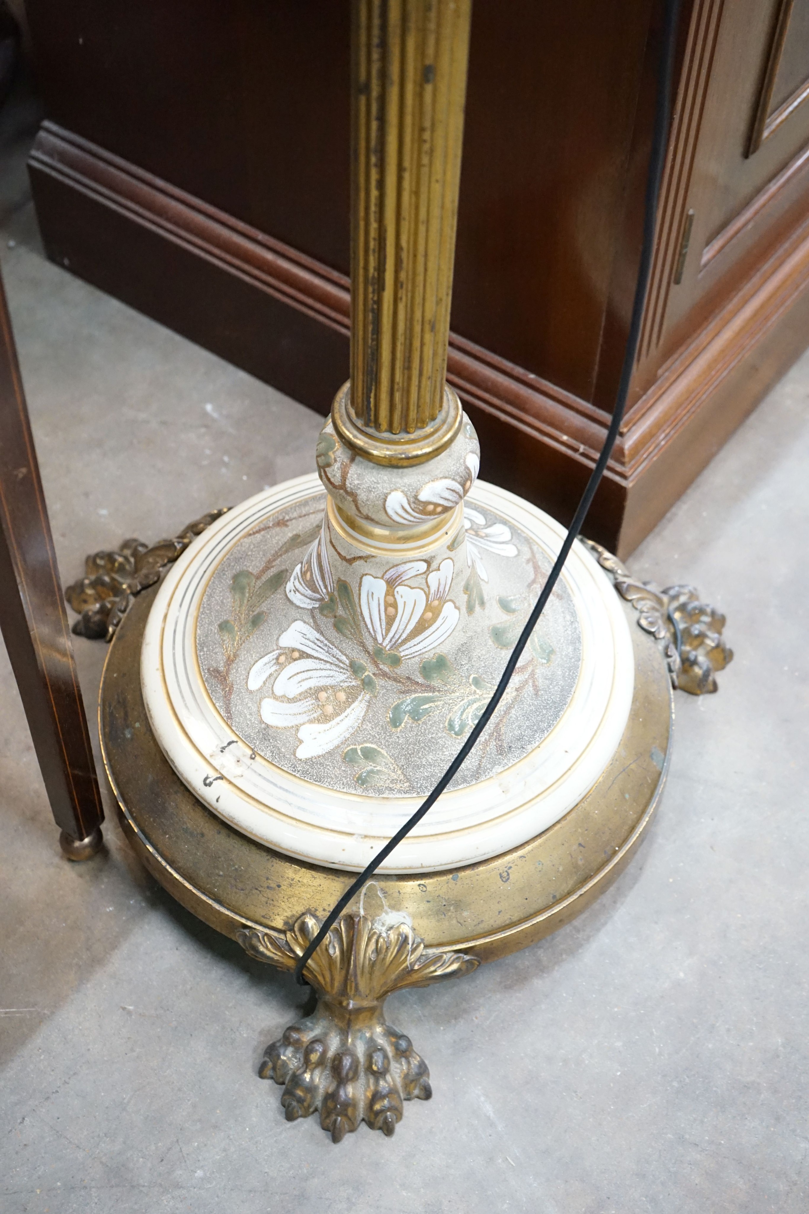 A brass and ceramic standard lamp on lion's paw feet, height 160cm